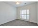 Bedroom with large window, neutral carpet, ceiling fan with light, and white walls at 206 Mountain Vista Blvd, Canton, GA 30115