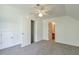 Bright bedroom featuring neutral carpet, ceiling fan with light, and entryways to closets and bathroom at 206 Mountain Vista Blvd, Canton, GA 30115