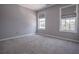 Empty bedroom showcasing neutral-colored walls and two windows with blinds, creating a serene ambiance at 392 Mill Pond Cossing, Carrollton, GA 30116