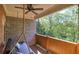 Back porch featuring a comfortable swing, brick walls, and views of lush trees at 636 Parkside Village Nw Way, Marietta, GA 30060