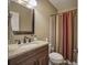 Bathroom featuring vanity with granite countertop, stained wood cabinets, and shower with curtain at 636 Parkside Village Nw Way, Marietta, GA 30060