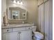 Cozy bathroom with a decorative mirror and a vanity featuring granite counters and modern fixtures at 636 Parkside Village Nw Way, Marietta, GA 30060