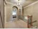 Upstairs hallway with decorative railing, arched doorway, and view into bedroom at 636 Parkside Village Nw Way, Marietta, GA 30060