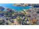 Aerial shot of a waterfront property featuring mature trees and a well-maintained lawn at 6460 Pine Ridge Cir, Cumming, GA 30041