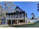 Back exterior of home featuring a screened-in porch, wooden deck, and a grassy yard at 6460 Pine Ridge Cir, Cumming, GA 30041