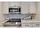 Kitchen featuring stainless appliances, tile backsplash and granite countertops at 6460 Pine Ridge Cir, Cumming, GA 30041