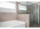 A bright bathroom features a soaking tub and frameless glass enclosed shower with tiled walls at 224 Gallant Fox Way, Acworth, GA 30102