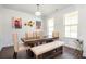 A modern dining room features hardwood floors, white walls, a wooden table, and wainscoting at 224 Gallant Fox Way, Acworth, GA 30102