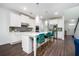 A modern kitchen features hardwood floors, white cabinets, stainless steel appliances and a center island at 224 Gallant Fox Way, Acworth, GA 30102