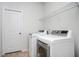 Clean laundry room with white front-loading washer and dryer and overhead shelving at 224 Gallant Fox Way, Acworth, GA 30102