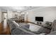 Open-concept living space with a modern sofa, hardwood floors, and seamless kitchen access at 4565 Grenadine Cir, Acworth, GA 30101