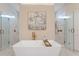 An elegant bathroom features a freestanding tub, gold fixtures, twin showers, marble flooring, and contemporary artistic decor at 4976 Concert Ln, Marietta, GA 30066