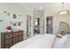 Light and airy bedroom featuring unique wall decor, a cozy chair, and a view into the Primary bathroom at 4976 Concert Ln, Marietta, GA 30066