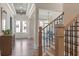 View of an elegant entryway with hardwood floors, a custom staircase and double glass front doors at 4976 Concert Ln, Marietta, GA 30066