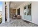Charming front porch showcasing stone flooring and columns, cozy seating, and stylish double front doors at 4976 Concert Ln, Marietta, GA 30066