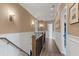 Upstairs hallway featuring a wood and iron railing, wainscoting, and hardwood floors at 4976 Concert Ln, Marietta, GA 30066
