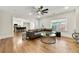 Bright living room with a leather sofa, ceiling fan, and an open view into the modern kitchen at 4976 Concert Ln, Marietta, GA 30066