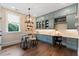 Well-lit office features custom blue cabinetry, a window, hardwood floors and a unique chandelier at 4976 Concert Ln, Marietta, GA 30066