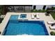 Aerial view of a swimming pool with integrated hot tub, lounge chairs, and covered patio with dining set at 4976 Concert Ln, Marietta, GA 30066