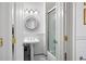 Bathroom with white subway tile and pedestal sink complemented by a round mirror and sconce lighting at 77 Peachtree Ne # 507, Atlanta, GA 30309