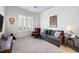Bright sitting room with a comfortable gray sofa, large window, and neutral carpet at 77 Peachtree Ne # 507, Atlanta, GA 30309