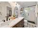 Chic bathroom featuring double vanity, modern lighting, and tiled shower with sliding glass door at 1168 Eggleston Sw St, Atlanta, GA 30310