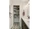 The bathroom linen closet provides ample storage with shelves and decorative baskets on stylish starburst tiles at 1168 Eggleston Sw St, Atlanta, GA 30310