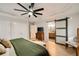 Spacious primary bedroom with modern fan, closet doors, and a barn-style door to the bathroom at 1168 Eggleston Sw St, Atlanta, GA 30310