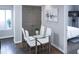 Dining area with a glass table, white chairs, and painting on the wall at 2161 Peachtree Ne Rd # 605, Atlanta, GA 30309