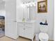 Bright bathroom featuring a white vanity, framed artwork, and adjacent door and toilet at 3040 Peachtree Nw Rd # 511, Atlanta, GA 30305