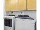 Bright laundry room features a side-by-side washer and dryer, as well as wooden cabinetry at 3040 Peachtree Nw Rd # 511, Atlanta, GA 30305