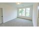This bedroom features neutral carpeting, white walls, a window with natural light, and base trim at 6565 Rhett Run, Cumming, GA 30028