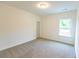This bedroom features neutral carpeting, white walls, a window with natural light, and base trim at 6565 Rhett Run, Cumming, GA 30028