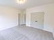 This bedroom features neutral carpeting, white walls, closet doors, and base trim at 6565 Rhett Run, Cumming, GA 30028
