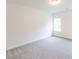 This bedroom features neutral carpeting, white walls, a window with natural light, and base trim at 6565 Rhett Run, Cumming, GA 30028