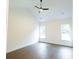 This bedroom features a vaulted ceiling, a ceiling fan, hardwood floors, and large windows allowing natural light at 6565 Rhett Run, Cumming, GA 30028