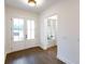 Bright foyer with double glass doors, dark hardwood floors, and neutral wall paint at 6565 Rhett Run, Cumming, GA 30028
