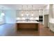 Spacious kitchen featuring a large island, stainless steel appliances, and stylish pendant lights at 6565 Rhett Run, Cumming, GA 30028