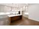 Bright kitchen boasts a large island, stainless steel appliances, and elegant pendant lighting at 6565 Rhett Run, Cumming, GA 30028