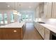 Gourmet kitchen with stainless steel appliances, a large island with a sink, and modern lighting at 6565 Rhett Run, Cumming, GA 30028