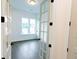 This office features glass paneled doors, hardwood floors, a window with natural light, and base trim at 6565 Rhett Run, Cumming, GA 30028