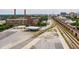 Wide aerial view of a brick building complex near train tracks and rail cars with a distant cityscape at 170 Boulevard Se # E006, Atlanta, GA 30312