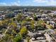 An aerial view of a neighborhood shows lush tree coverage and a distant skyline under a picturesque sky at 218 Barry St, Decatur, GA 30030