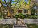 Charming two-story yellow home with a white picket fence and lush landscaping at 218 Barry St, Decatur, GA 30030