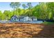 View of the backyard featuring a modern white house, lush greenery, and a pristine pool area at 295 Hollyberry Dr, Roswell, GA 30076