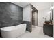 Modern bathroom with stylish stone wall accent, soaking tub, glass enclosed shower, and double sink vanity at 295 Hollyberry Dr, Roswell, GA 30076