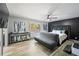 Bedroom featuring a large wall-mounted television, a futon, a black accent wall, and light hardwood floors at 295 Hollyberry Dr, Roswell, GA 30076