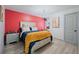 This bedroom features a vibrant red accent wall, complemented by stylish furnishings and light gray flooring at 295 Hollyberry Dr, Roswell, GA 30076