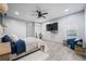 This is a comfortably designed bedroom with a ceiling fan, a mounted TV, and light gray wood flooring at 295 Hollyberry Dr, Roswell, GA 30076