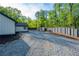 Gravel driveway showcasing ample parking and a modern home design with dark fencing for privacy at 295 Hollyberry Dr, Roswell, GA 30076
